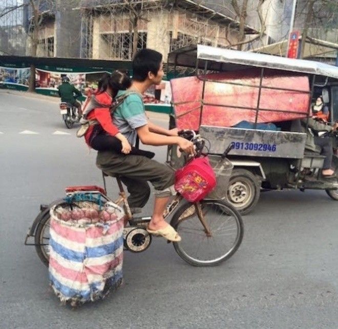 Bức ảnh cha vừa đạp xe địu con trên lưng vừa ngân nga ca hát ở Hà Nội