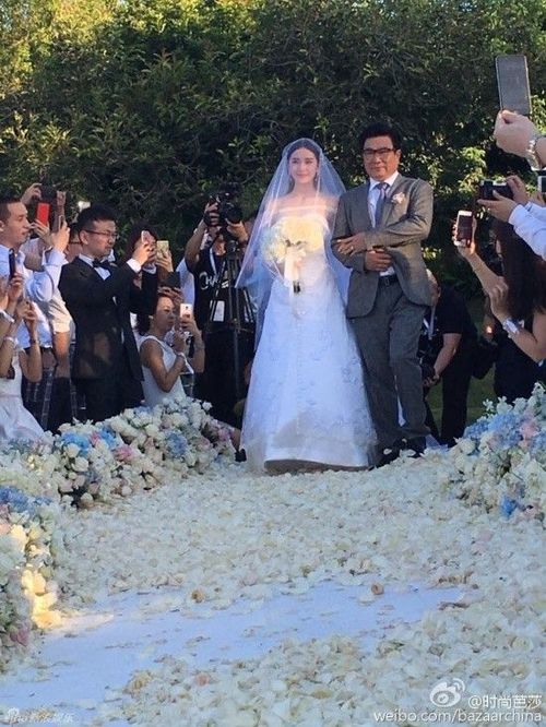 Cô dâu Lưu Thi Thi xuất hiện bên cạnh cha, cô được ông nắm tay tiến vào sảnh chính của hôn lễ.