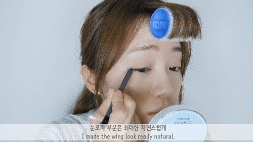 Với cây eyeliner đen, ta kẻ eyeliner "giấu" thật mảnh cho viền mắt trên, tạo đuôi mắt cong nhẹ và sử dụng cây tăm bông để đường kẻ được mềm mại, tự nhiên hơn.