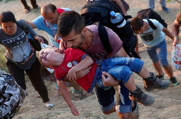 Một cậu bé người Syria khóc lóc khi được cha bồng trên tay khi cả hai đang cố gắng vượt biên giới vào Hy Lạp, ngày 3/9.