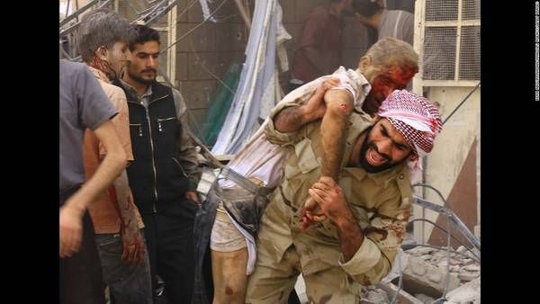 Một người lính đang khiêng người dân bị thương sau trận không kích của quân đội Syria tại tỉnh Damascus ngày Thứ 5 17/09. Cuộc nội chiến tại Syria tới thời điểm này đã bước sang năm thứ 5.