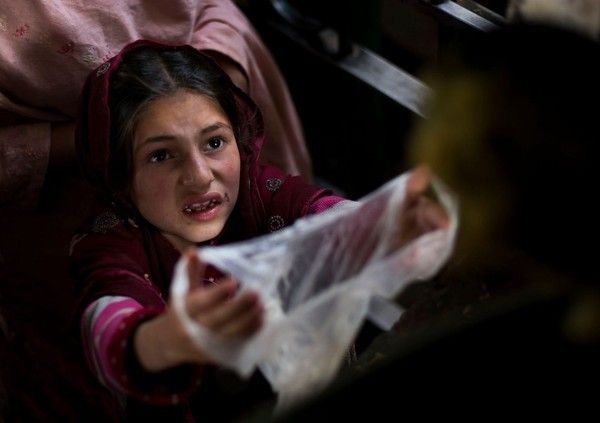 Cô bé nghèo người Pakistan đang đi xin thức ăn từ thiện cho cả gia đình trong một buổi phát thức ăn được tổ chức tại ngôi đền địa phương phía ngoại ô thủ đô Islamabad.