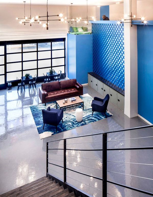Trụ sở của hãng tư vấn marketing Bluecore được thiết kế mang âm hưởng cổ điển với tông màu chủ đạo là xanh dương, đúng như cái tên của công ty. Trước đây nơi này chính là một shop bán rượu cổ, từ đó kiến trúc sư đã tận dụng không gian hoài cổ như những chùm đèn trần vàng óng, bộ sô pha da nâu bóng làm điểm nhấn. Hơn nữa, một góc làm việc kiểu tổ chim đại bàng còn là nơi bất kỳ nhân viên nào có thể ôm laptop ngồi lên ý tưởng và còn quan sát được mọi chuyện phía dưới.