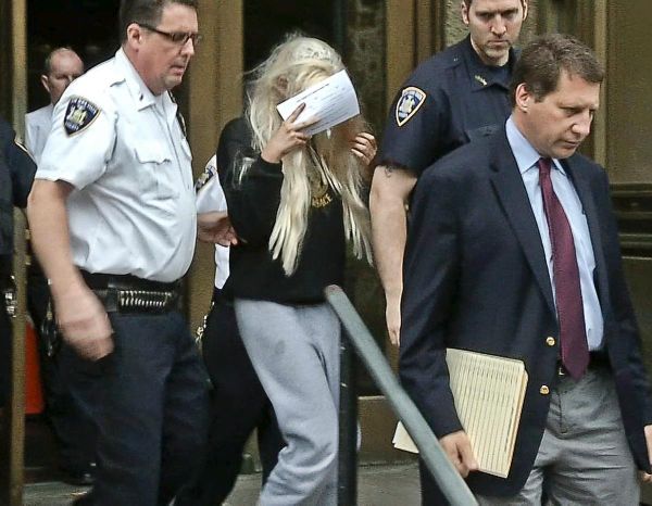 Ngôi sao trẻ một thời Amanda Bynes đầu tóc bù xù, cầm tờ báo che mặt khi bước ra từ tòa án hồi tháng 5/2013. Nữ diễn viên bị bắt vì tội danh ném ống tẩu hút ma tủy ra khỏi căn hộ ở tầng thứ 36 của một tòa nhà. Sau phiên tòa, Amanda bị đưa đến nhà giam.