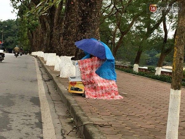 Người bán vé số quây kín xung quanh tránh cái rét cắt da cắt thịt - (Ảnh: Định Nguyễn)