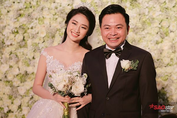 Hai vợ chồng vui vẻ đón tiếp quan khách.